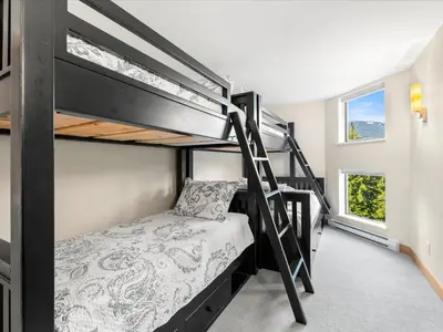 a bedroom with two bunk beds and a window at Ski In/Out, Steam Shower, Pool, Hot Tub, Sauna in Whistler