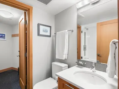 a bathroom with a sink and a toilet and a mirror at Ski In/Out, Steam Shower, Pool, Hot Tub, Sauna in Whistler