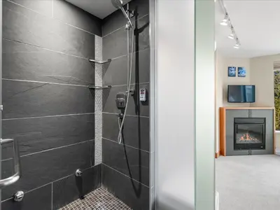 a bathroom with a shower with a fireplace at Ski In/Out, Steam Shower, Pool, Hot Tub, Sauna in Whistler