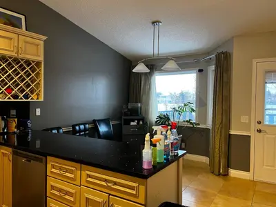 a kitchen with a black counter top and a window at citadel cozy quilt private bedroom in Calgary