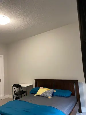a bedroom with a bed and a table with a chair at Flowealth Property Luxury Villa Near Lake Netflix TV Wifi in Calgary