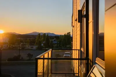 a view of the sunset from a balcony of a building at Bright Modern Stylish Condo in heart of Downtown (Center) in Whitehorse