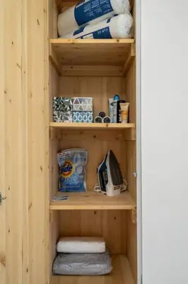 a wooden shelf with towels and other items on it at Downtown Near Rogers Place with Covered Parking, Sleeps 6, Pool Table, Sauna, Gym, Two Bedrooms & More in Edmonton