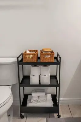 a bathroom with a shelf with towels and baskets at Downtown Near Rogers Place with Covered Parking, Sleeps 6, Pool Table, Sauna, Gym, Two Bedrooms & More in Edmonton