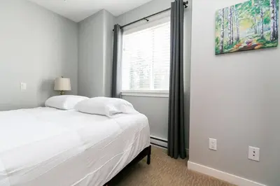 a white bedroom with a bed and a window at Entire 3-bedroom house Near Town in Victoria