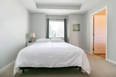 a white bedroom with a large bed and a window at Entire 3-bedroom house Near Town in Victoria