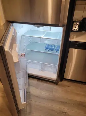 an empty refrigerator with its door open in a kitchen at Cozy brand new 2 bedroom suite in Calgary in Calgary