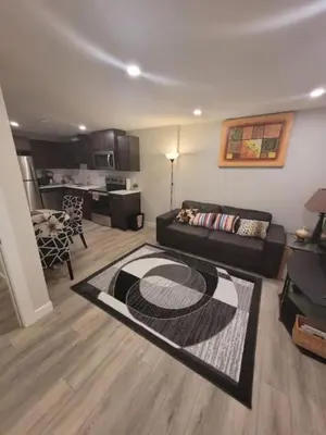 a living room with a couch and a kitchen at Cozy brand new 2 bedroom suite in Calgary in Calgary