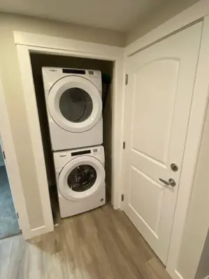 a laundry room with a washing machine and a washer at Cozy brand new 2 bedroom suite in Calgary in Calgary