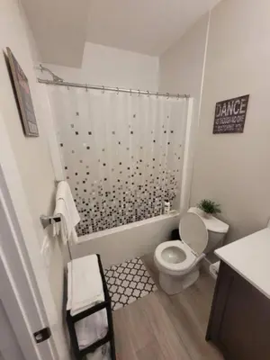 a small bathroom with a toilet and a shower at Cozy brand new 2 bedroom suite in Calgary in Calgary