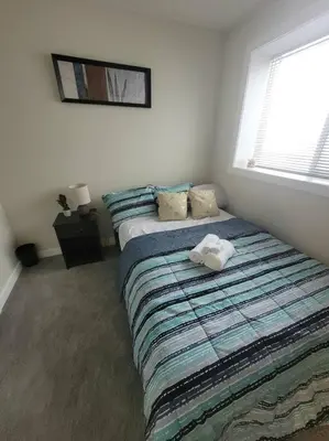 a bedroom with two beds and a window at Cozy brand new 2 bedroom suite in Calgary in Calgary