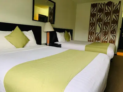 a hotel room with two beds and a mirror at Hotel at the Waldorf in Vancouver