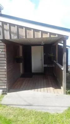 a wooden deck with two potted plants on it at Orca Lodge in Sointula