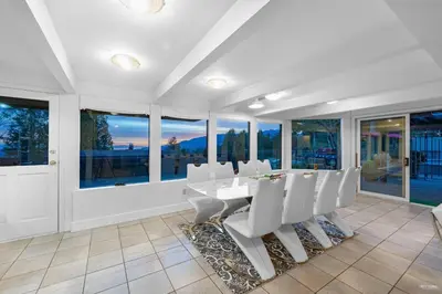 a dining room with white chairs and windows at Private Bedroom, Bathroom, Shared Outdoor Pool, Hot Tub in North Vancouver