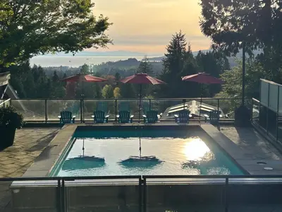 a swimming pool with chairs and umbrellas at Private Bedroom, Bathroom, Shared Outdoor Pool, Hot Tub in North Vancouver