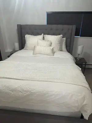 a large white bed with two pillows on it at Carrington Chateau in Vancouver