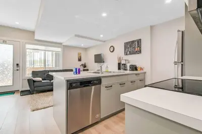 a kitchen with a sink and a stove top oven at Brand New Executive Suite in Calgary