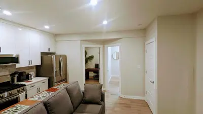 a living room with a couch and a kitchen at Cozy basement for a lovely stay & perfect for WFH in Edmonton