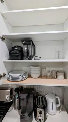 a kitchen shelf with dishes and appliances on it at Cozy basement for a lovely stay & perfect for WFH in Edmonton