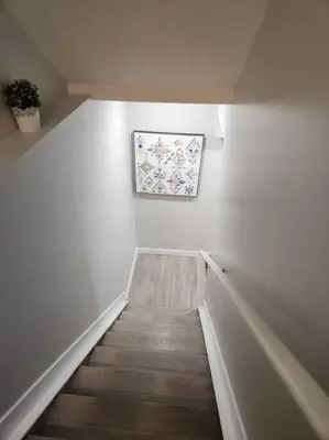 a hallway with a staircase with a painting on the wall at Cozy basement for a lovely stay & perfect for WFH in Edmonton