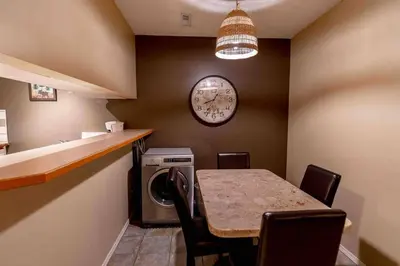 a dining room with a table and a clock on the wall at Mountain view walk to all in Canmore Canada in Canmore