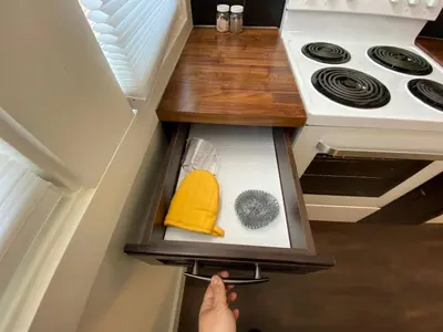 a person reaching into an open drawer in a kitchen at Brand New 1 Br 1 Bath Close To All Walkable in Edmonton