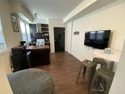 a living room with a television and a table and stool at Brand New 1 Br 1 Bath Close To All Walkable in Edmonton