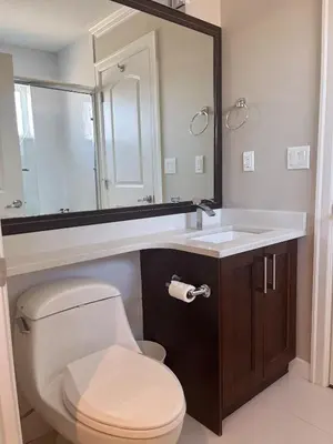 a bathroom with a toilet and a sink and a mirror at Near Skytrain and QUIET Private Bedroom Ensuite BathRM, Free Wifi & Coffee, Cozy in Burnaby