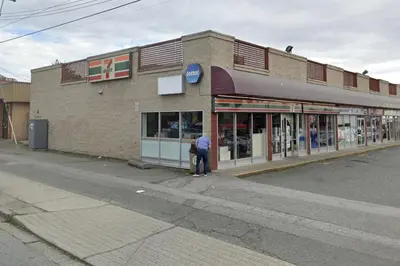 a person standing outside of a store on a street at Near Skytrain and QUIET Private Bedroom Ensuite BathRM, Free Wifi & Coffee, Cozy in Burnaby