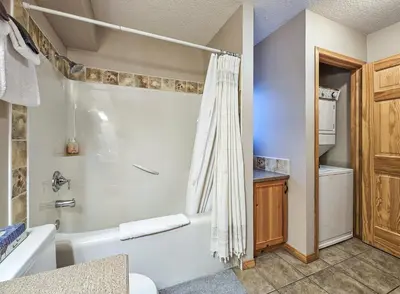 a bathroom with a white tub and a shower at Pine Cone Cabin by StayIn in Radium Hot Springs