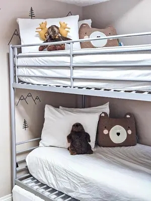 a childs bedroom with white bunk beds with stuffed animals at Pine Cone Cabin by StayIn in Radium Hot Springs
