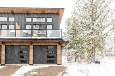 a house with a deck in the snow at 22 Sunniva by StayIn in Fernie