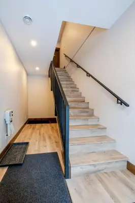 a staircase in a room with wooden floors and a stair case at 22 Sunniva by StayIn in Fernie