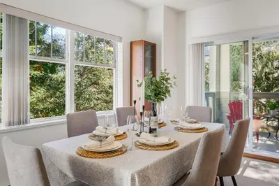 a dining room with a table and chairs and windows at Desirable Blueberry Hill in Whistler