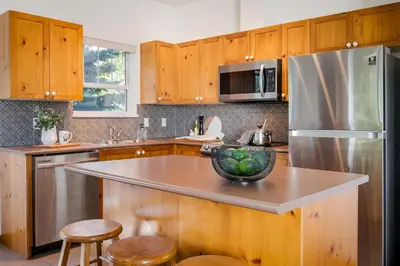 a kitchen with wooden cabinets and a stainless steel refrigerator at Desirable Blueberry Hill in Whistler