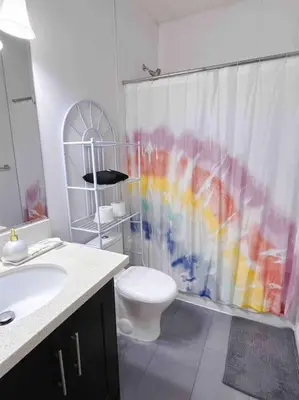 a bathroom with a toilet and a shower curtain at Si & Daniel Home Near YVR Airport & Skytrain Separate Entry Free Parking in Richmond