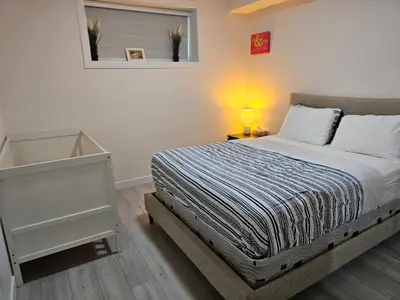 a bedroom with a bed and a lamp on a table at New built house, Stay in Style Guest Suite, 2bedroom, 2bed, 2bath in Edmonton