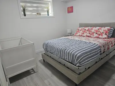 a bedroom with a bed and a dresser and a mirror at New built house, Stay in Style Guest Suite, 2bedroom, 2bed, 2bath in Edmonton
