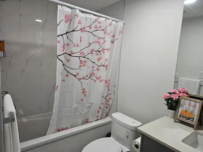 a bathroom with a toilet and a shower curtain at New built house, Stay in Style Guest Suite, 2bedroom, 2bed, 2bath in Edmonton