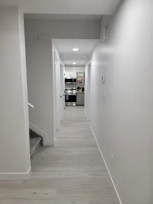 a hallway with white walls and a wooden floor at New built house, Stay in Style Guest Suite, 2bedroom, 2bed, 2bath in Edmonton