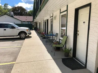 a white truck parked next to a building with chairs at Chase Country Inn in Chase