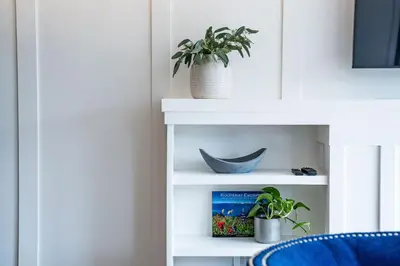 a white shelf with a plant and a blue chair at Stoked 4Ever - Revelstoke Condo (+Hot Tub) in Revelstoke