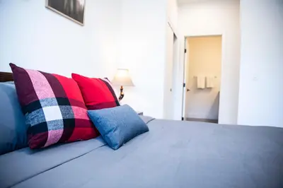 a bed with colorful pillows on top of it at Selkirk Powder Dream - Cozy Condo (+Hot Tub) in Revelstoke