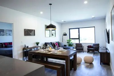 a kitchen and living room with a table and chairs at Selkirk Powder Dream - Cozy Condo (+Hot Tub) in Revelstoke