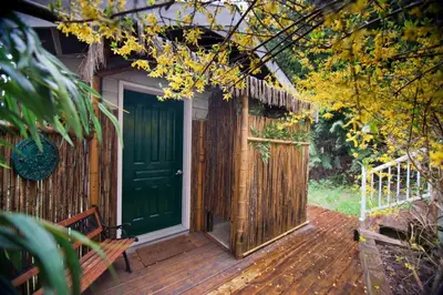a wooden deck with a green door and a bench at Madeira Park Oceanview Suites in Madeira Park