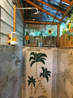 a bathroom with a palm tree mural on the wall at Madeira Park Oceanview Suites in Madeira Park