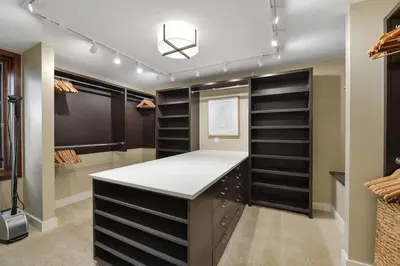 a walk in closet with black shelves at Island Luxury Oceanside Estate by EMR Vacation Rentals in Saanichton