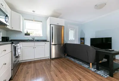 a kitchen with a stainless steel refrigerator and a table at Great 1-bedroom Suite Near Downtown Langford in Victoria