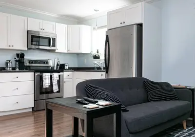 a living room with a couch and a kitchen at Great 1-bedroom Suite Near Downtown Langford in Victoria