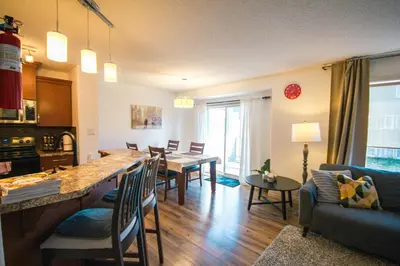 a kitchen and living room with a table and chairs at Entire Home AC 4Beds Sleeps 8 Double Garage Near WEM Free Wifi & Netflix in Edmonton